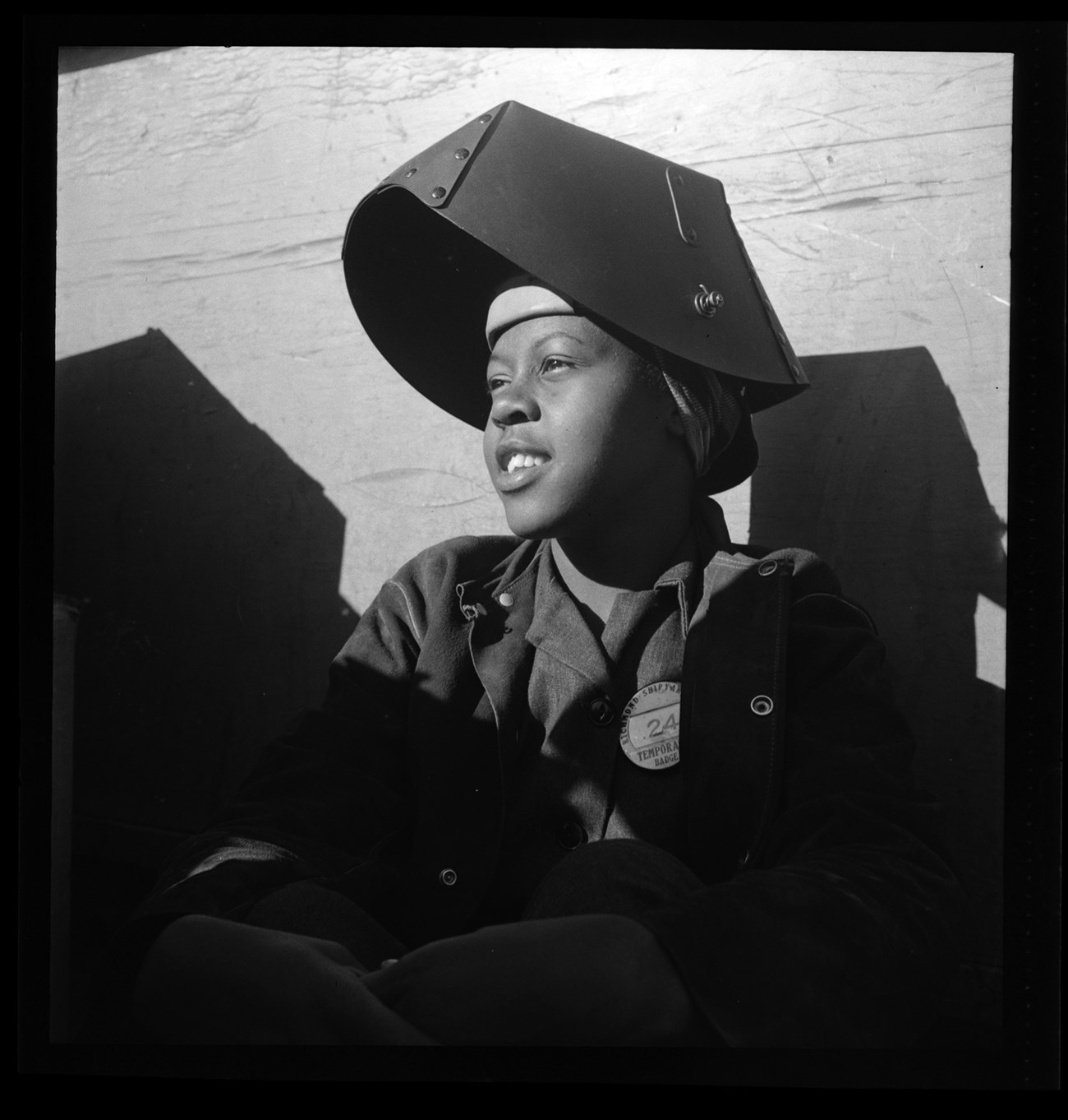Portrait of young African American woman in welder’s helmet.