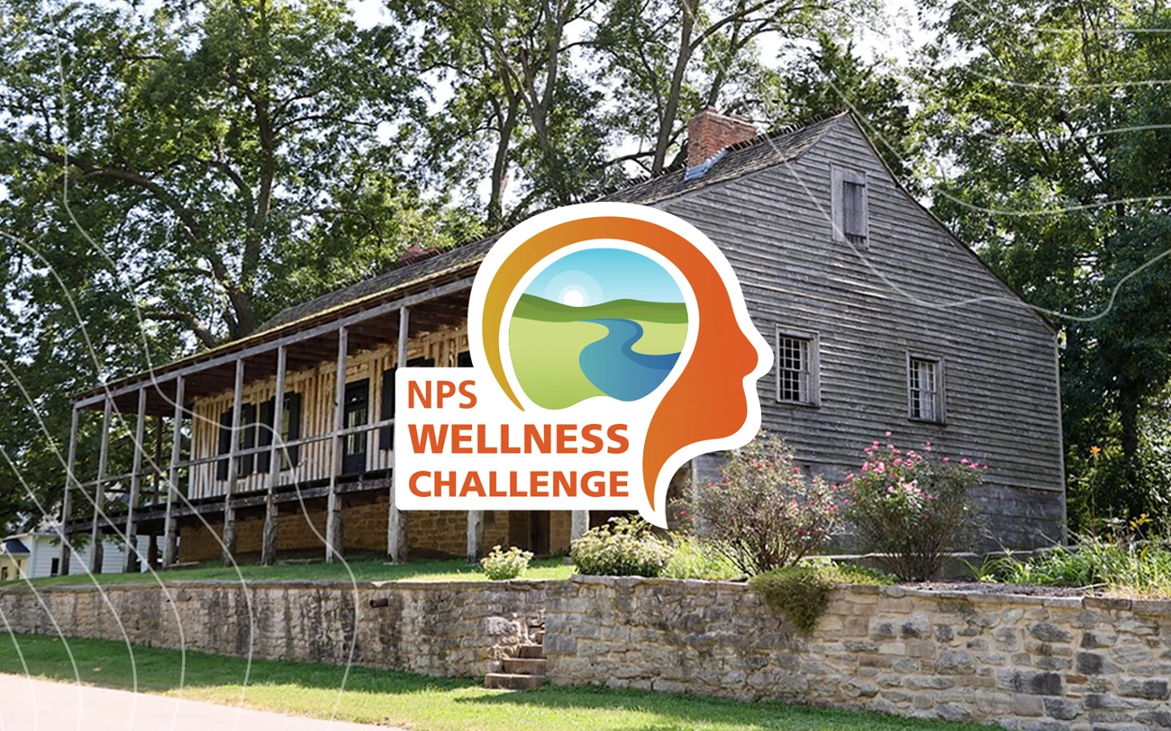 Ste. Geneviève NPS Wellness Hero A historic log home with a logo of a landscape inside a person's head with text reading NPS Wellness Challenge