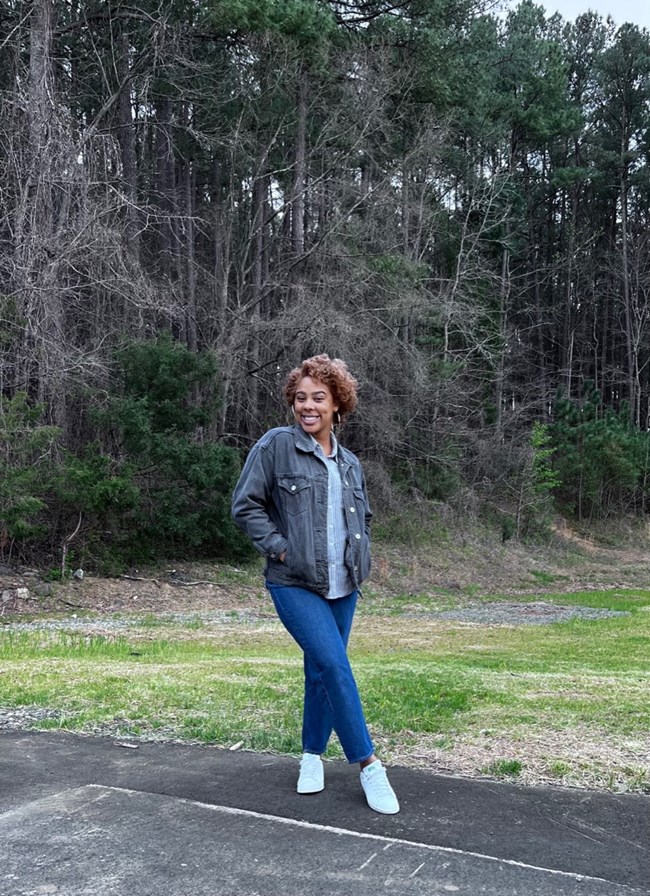 Subria smiling while posing at a park surrounded by nature
