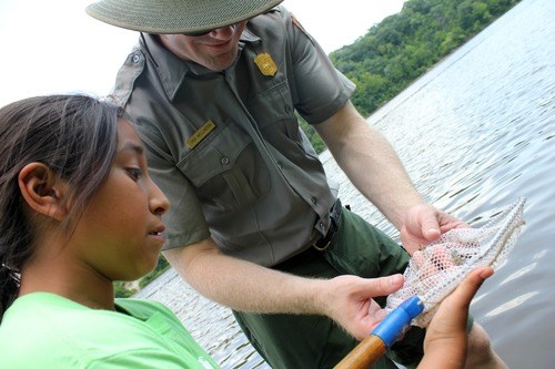 A student checking water quality with a Teacher-Ranger-Teacher at the Mississippi National River and Recreation Area