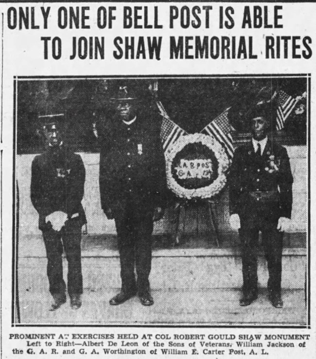 Three veterans standing in front of the Shaw/54th Regiment Memorial on Memorial Day.