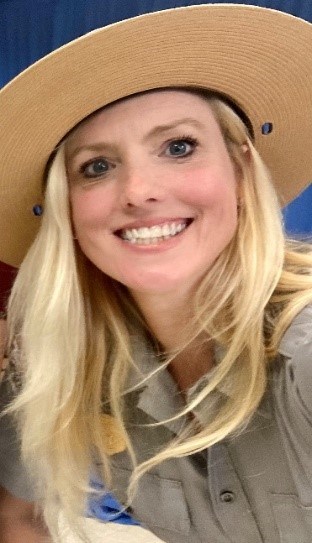 Tracy O'Toole A close-up image of a blonde woman in a tan round hat smiling.