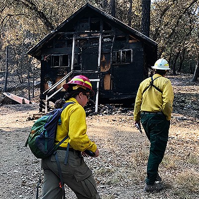 NPS employees asses damage to burnt historic cabin