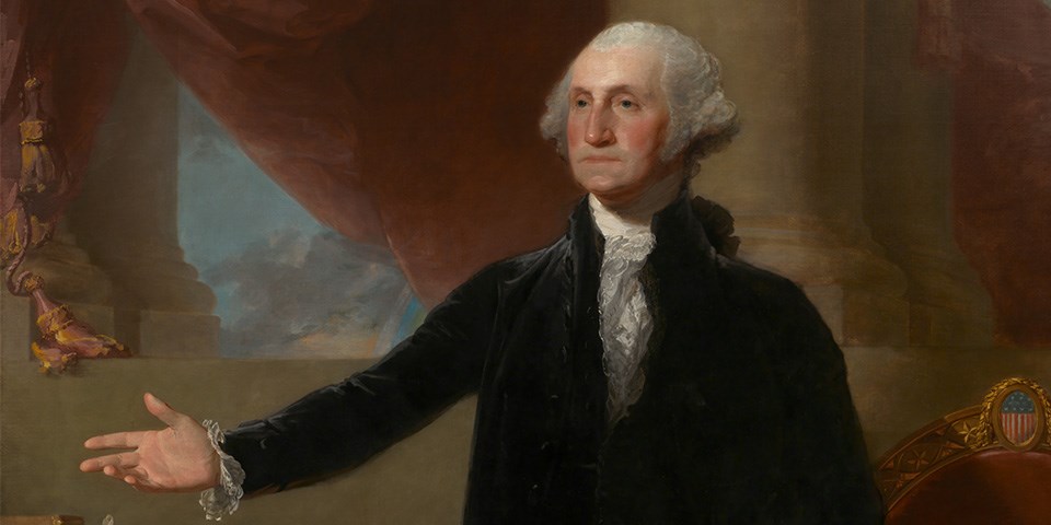George Washington wearing a black coat with his right arm outstreched.