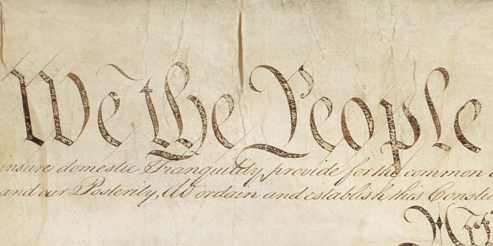 Close-up image of "We the People" written on the Constitution.