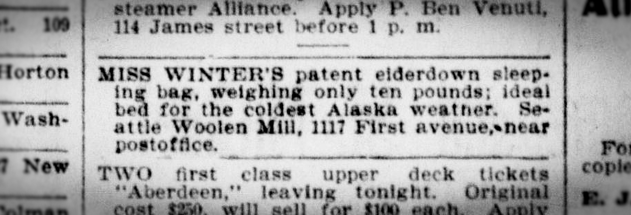 A close-up of an original newspaper advertisement for Sarah Winters’ sleeping bag. A close-up of an old newspaper advertisement saying: Miss Winters' patent elderdown sleeping bag, weighing only ten pounds; ideal bed for the coldest alaska weather. Seattle woolen mill, 1117 First avenue, near post office.