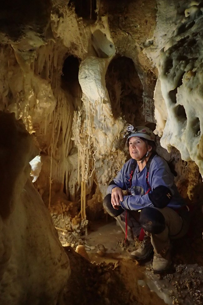a person in a cave looking at the cave formations