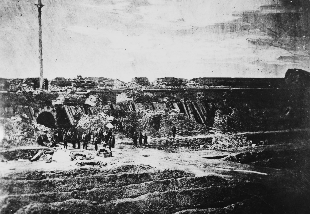 Black and white photograph of a battle damaged fort.