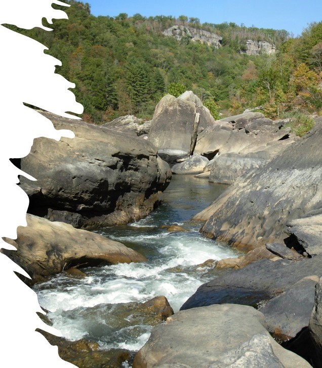 water flows over large rocks and boulders