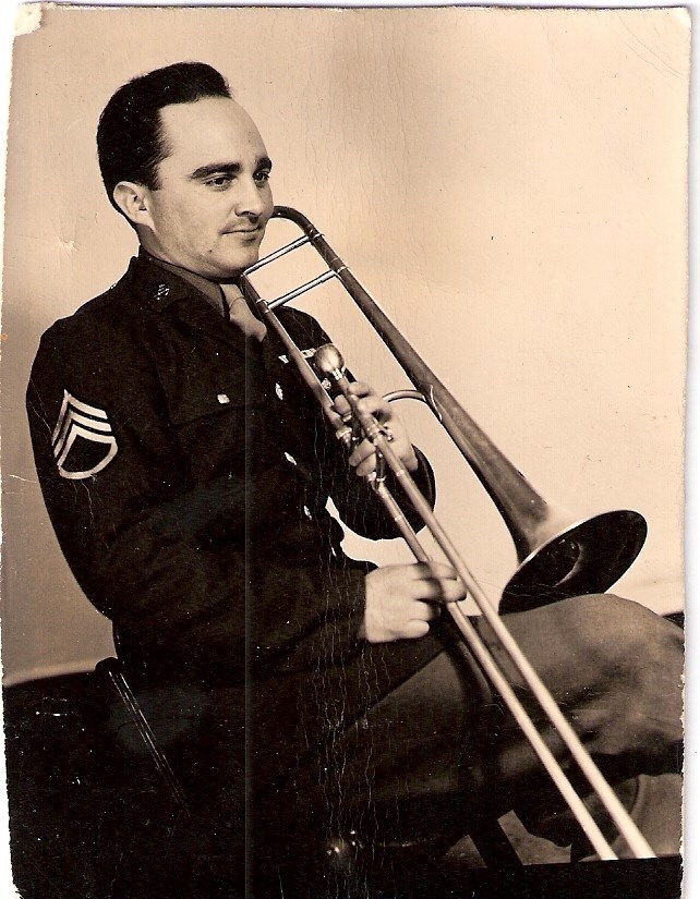 Bob Johnson playing trombone seated man in uniform playing a trombone.