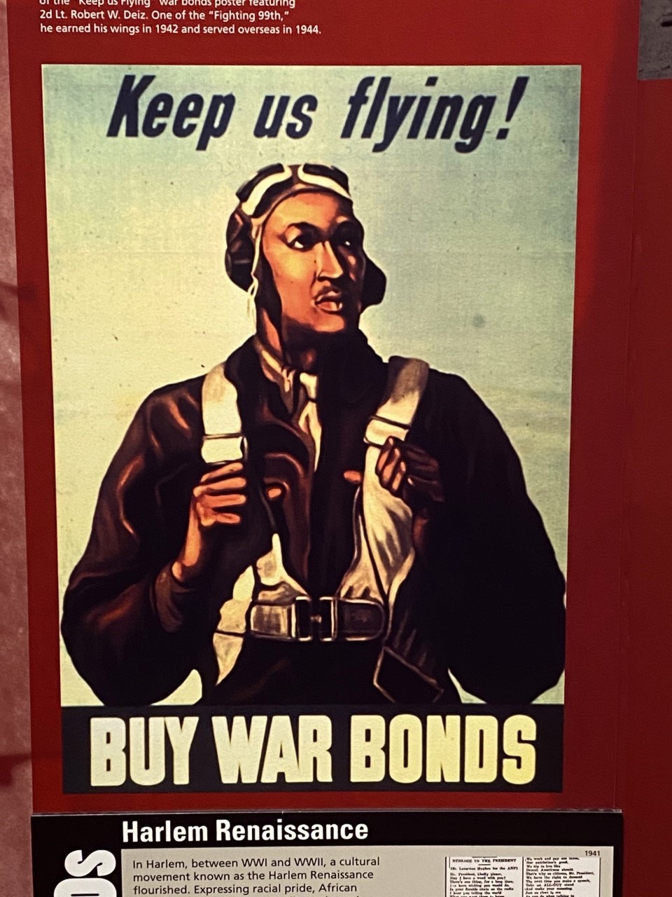 A 1942 WWII propaganda poster on display at Tuskegee Airmen National Historic Site featuring a Tuskegee Airman WWII propaganda poster. "Keep us fling! BUY WAR BONDS"