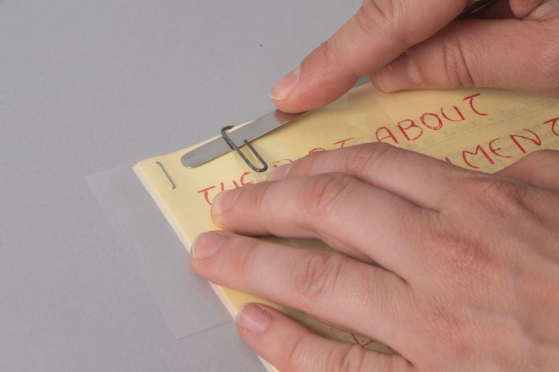 Demonstrating how to remove a metal paperclip.