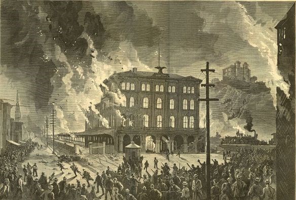 building is on fire while a mob of people look on