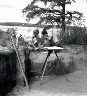 Two people huddle over a site