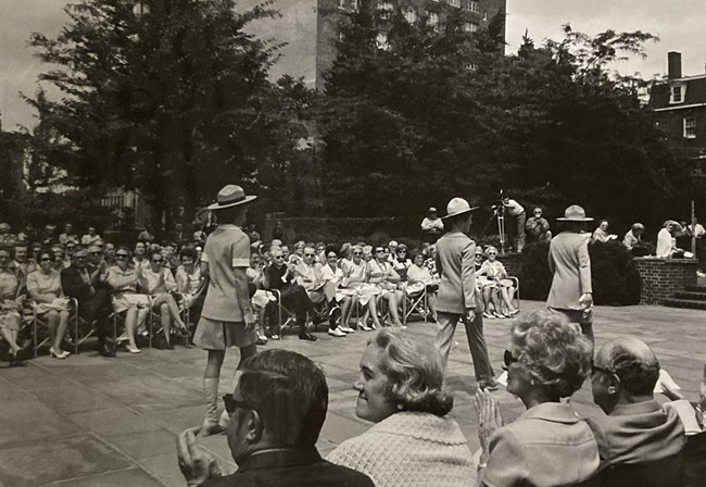 Independence Fashion Show Women model NPS uniforms in front of a seated crowd.