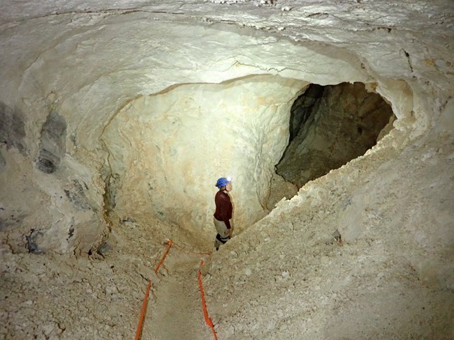 very white cave passage with a person standing in it
