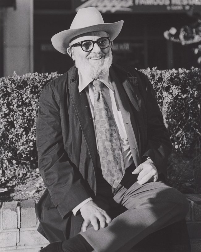 Portrait of Ansel Adams as an old man in a suit with hat and beard