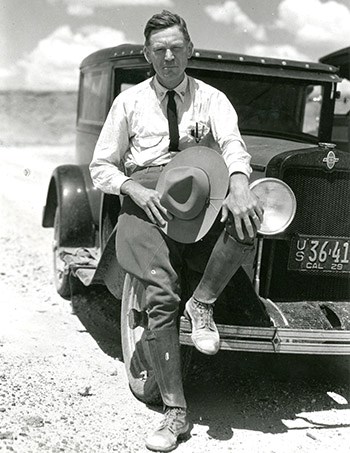 Frank "Boss" Pinkley Frank Pinkly sitting on an old car with a foot on the fender and a wide-brimmed hat in his hand.
