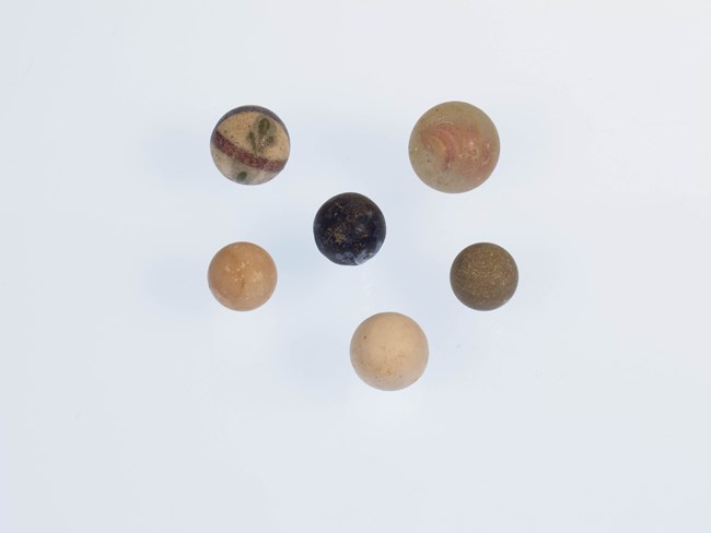 six marbles, made of glass, porcelain, or ceramics.