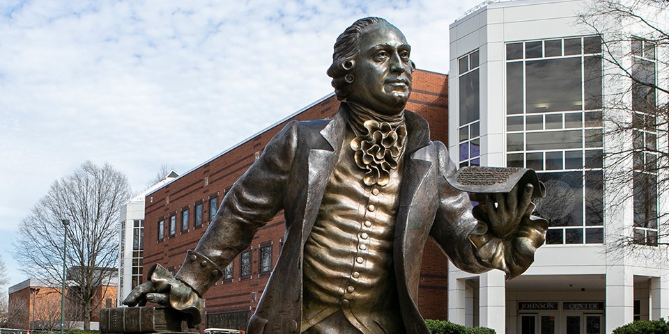 Statue of Mason standing leaning forward presenting a piece of paper.