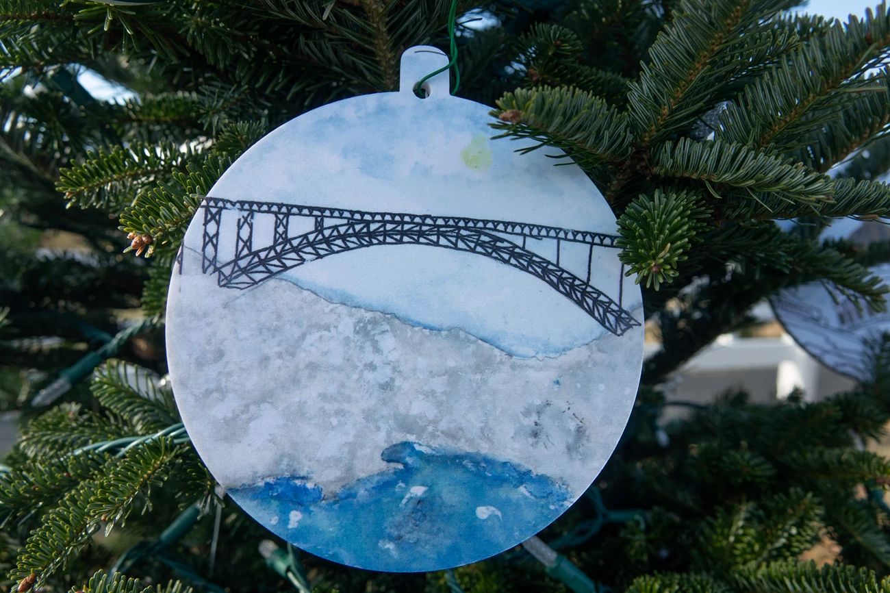 new river gorge national christmas tree 2021 ornament with drawing of a bridge. Ornament is hanging from chritmas tree