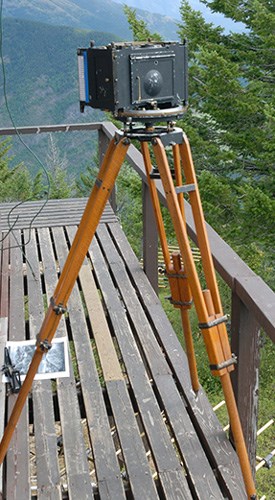 Camera mounted on a tripod set up on a deck