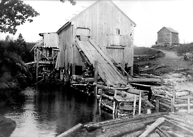 B&W photo of sawmill above water