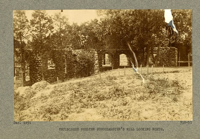 Black and white photographs of stone ruins with many arches on a hill