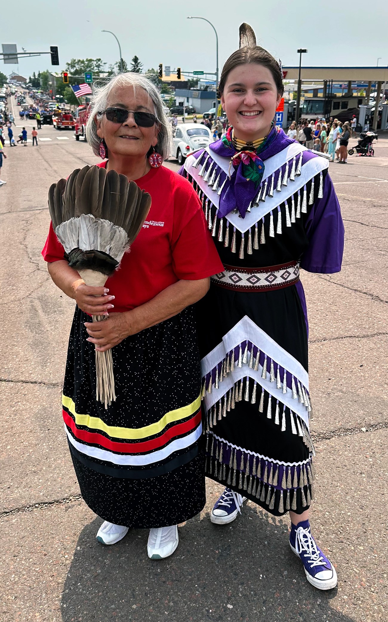 Two people wearing traditional Ojibwe clothing