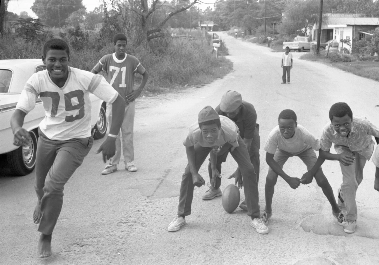 Boys playing football on a country road Boys playing football on a country road