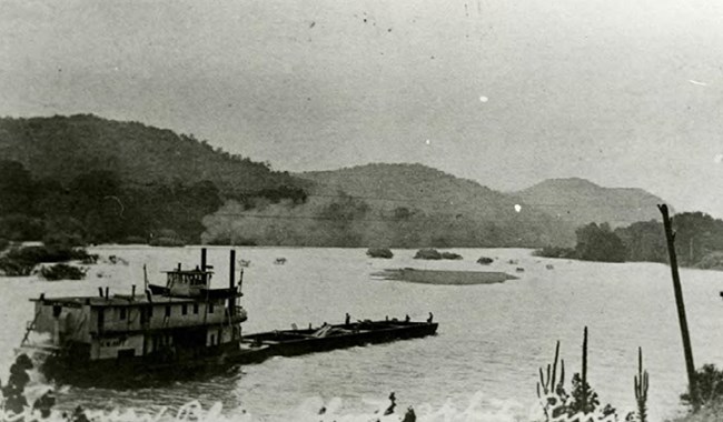 Photograph of a steamboat pushing a barge on the White River in Arkansas