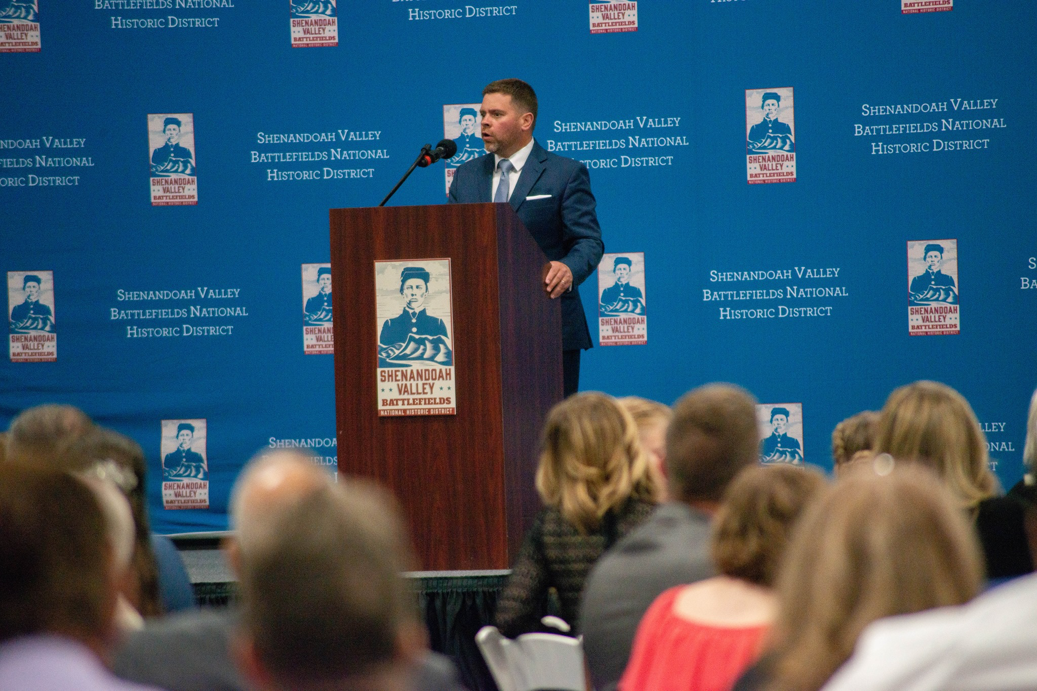 Man stands speaking at podium