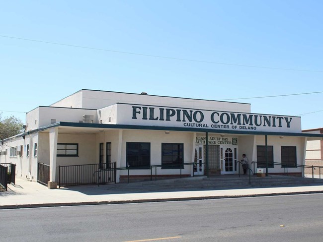 Exterior of white building with green painted lettering