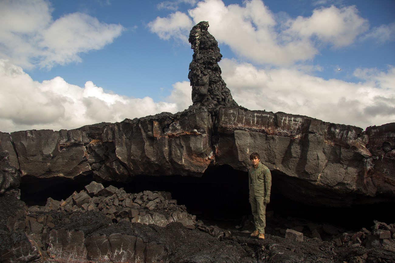 photo of a person standing near a tall rock spire