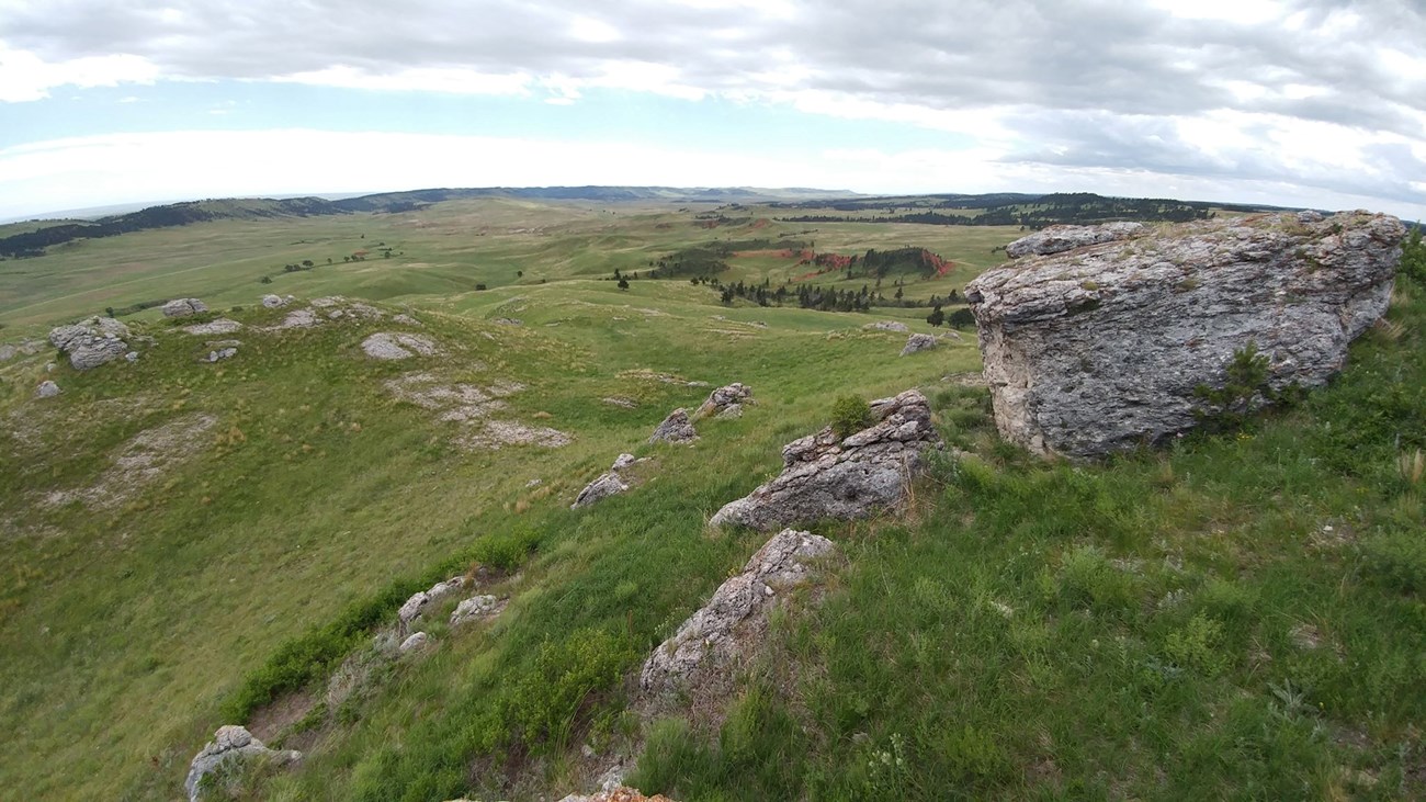 wide view of a prairie scene with rock outcrops