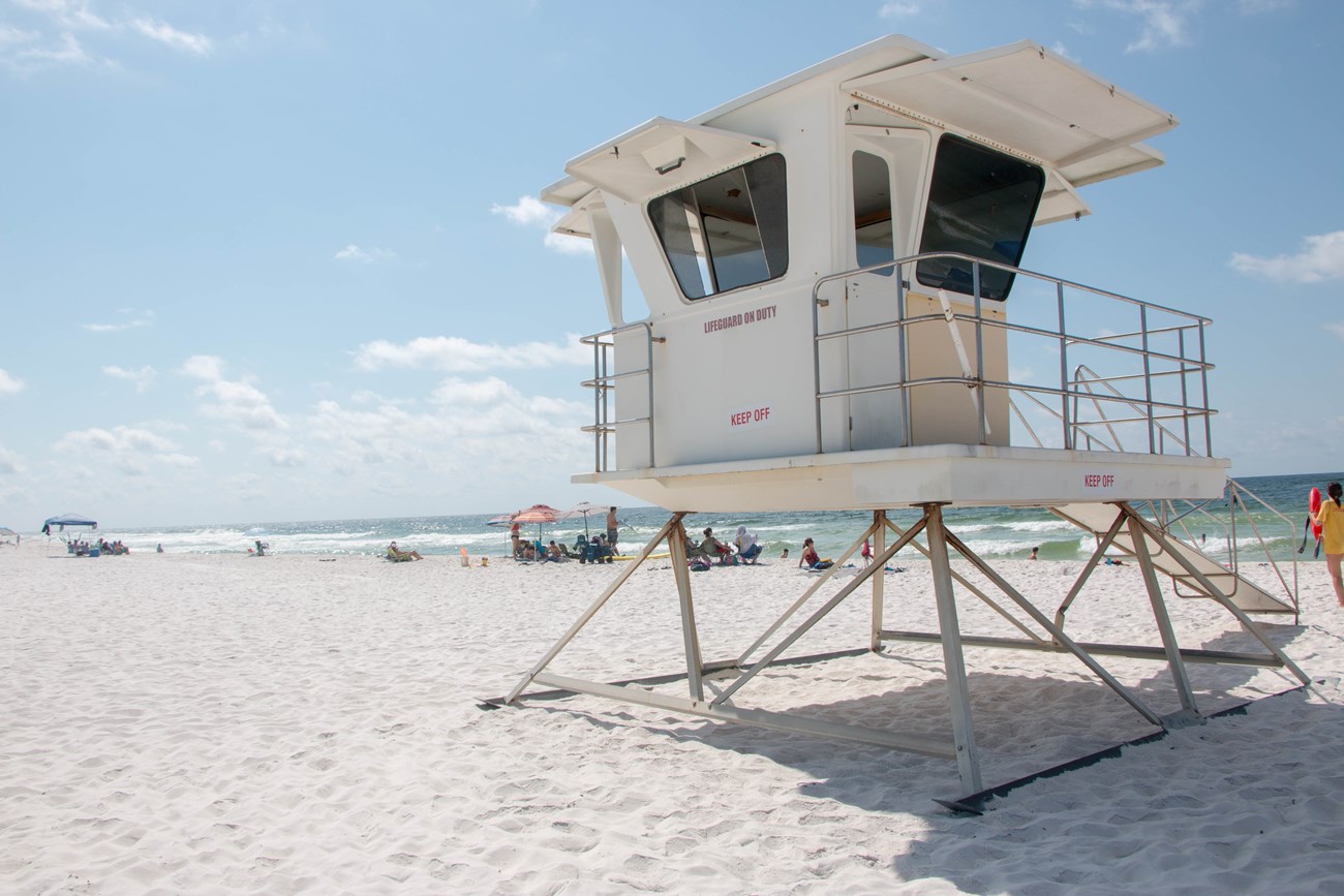 A lifeguard tower stands on a beach.