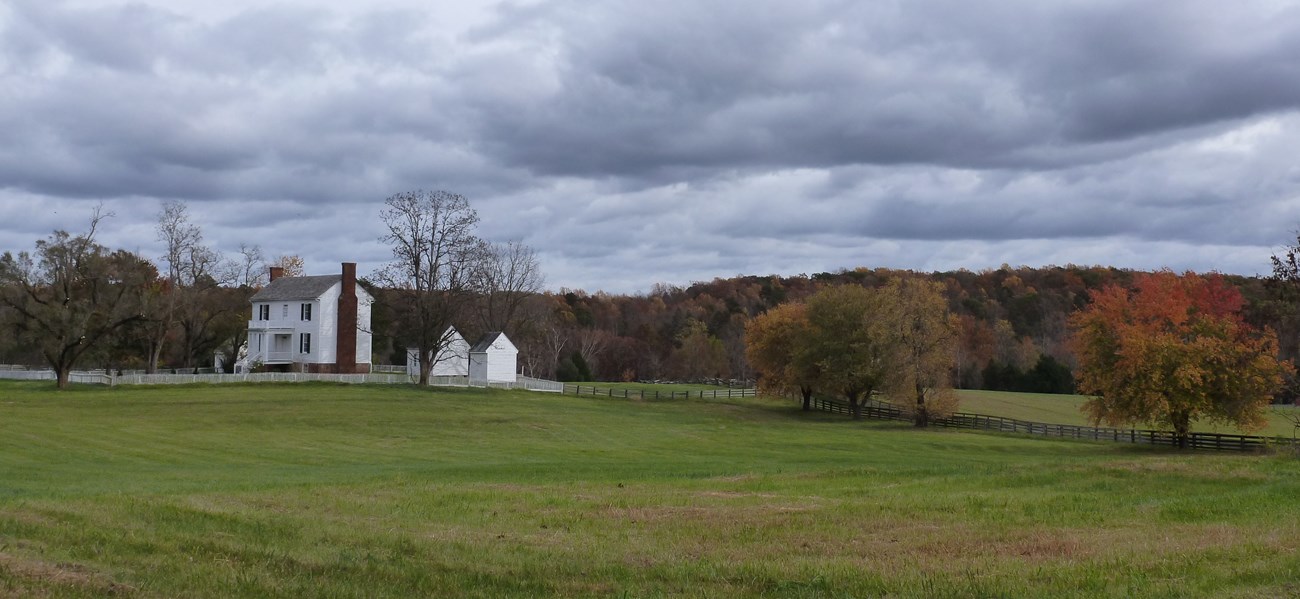 8132157217_88804877de_o_peershouse_Bruce_Washburn_APCO_CMS Peers house as viewed from a distance across a green field with storm clouds in the background