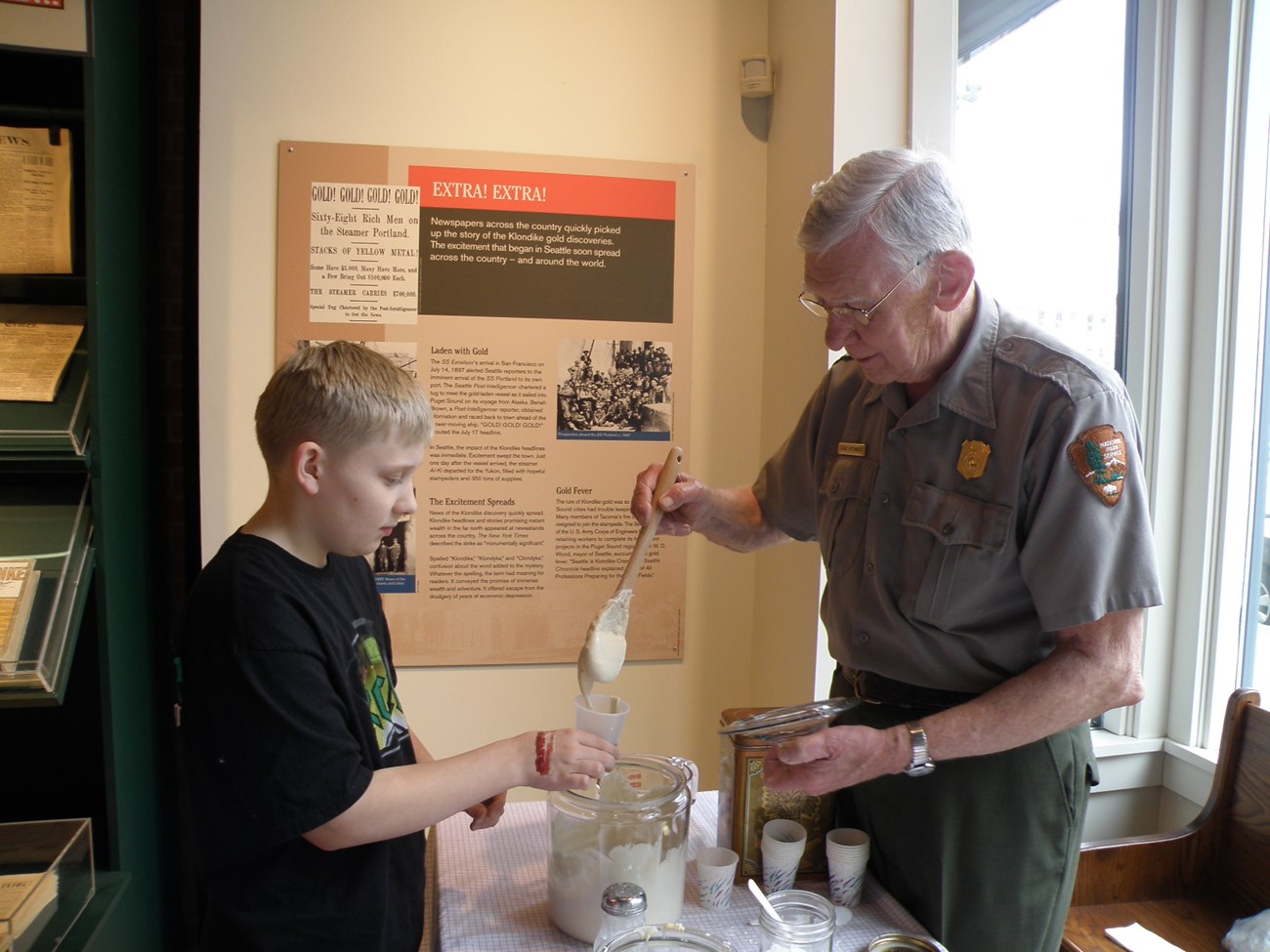 Ranger mixing sourdough in a demonstration with a child