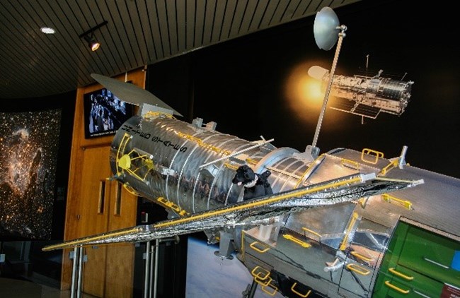 toy dog on model of the HUbble Space Telescope