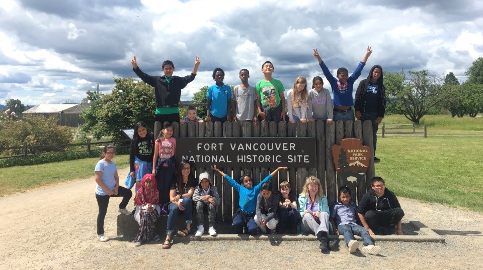 Photo of a group of students posing by the entrance sign to Fort Vancouver.