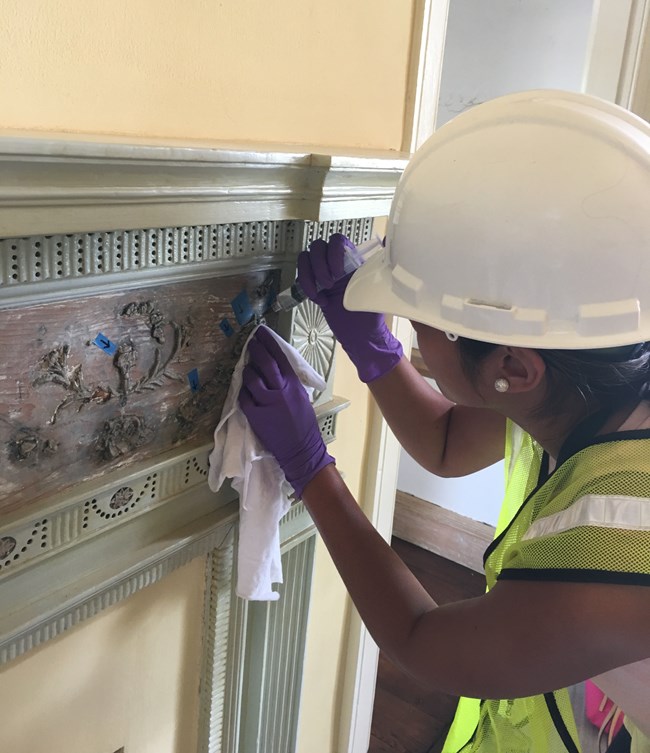 NPS intern stabilizes ornaments on mantelpiece with injectable glue.