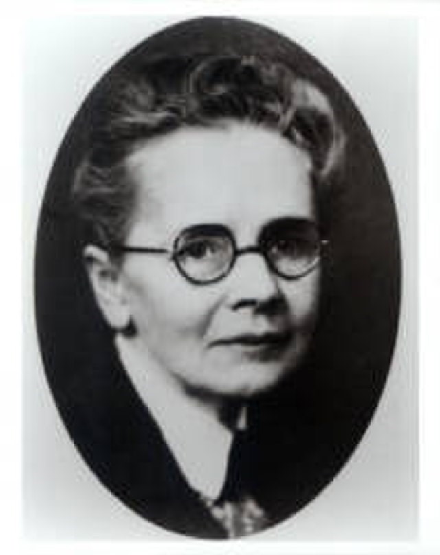 Julia Morgan Black and white photograph of Julia Morgan, a white woman with gray hair wearing glasses with round, black frames. The picture is closely cropped in an oval around her face and neck.