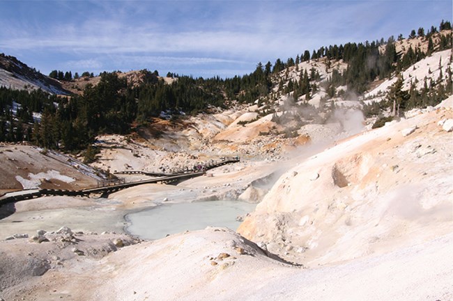 geothermal area with steaming pool and barren slopes