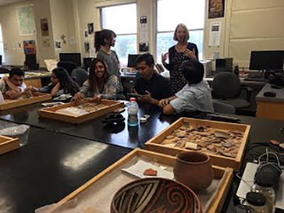 Students work on archeological artifacts in a lab