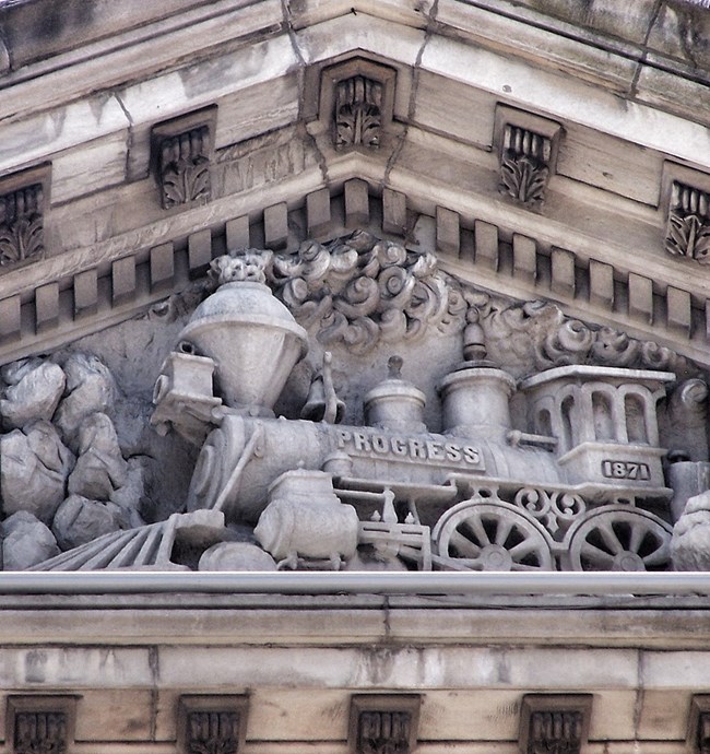 Detail, pediment of Louisville City Hall showing the train. Photo by Bill Badzo, CC BY NC 2.0