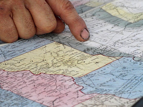 Historic Missouri Map A hand points a dirty finger at a map of the American Midwest.