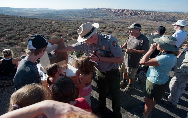 May 20 2012 Eclipse Viewing at Arches No Glasses NPS Neal Herbert A Park Ranger teaching visitors about viewing an eclipse without looking directly into the sun. The Park Ranger is using a projection tool to view the eclipse.
