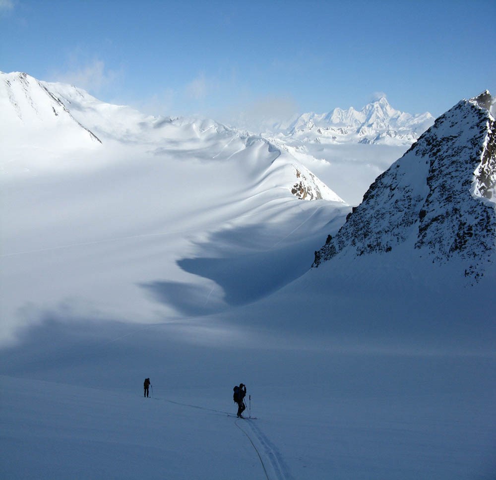 Skiers in a snowy wilderness.