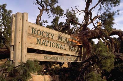 Rocky Mountain National Park sign has fallen tree on it, leaving it broken.