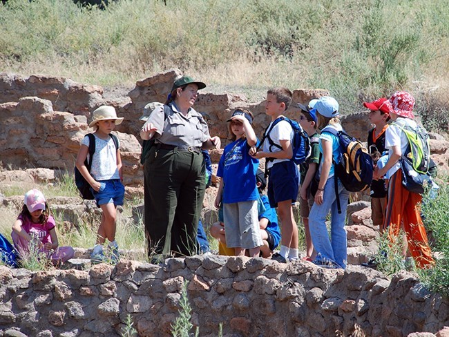 A ranger teaches kids about a Kiva at Bandelier National Monument NPS